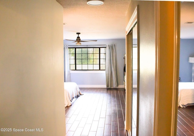 corridor with hardwood / wood-style floors and a textured ceiling