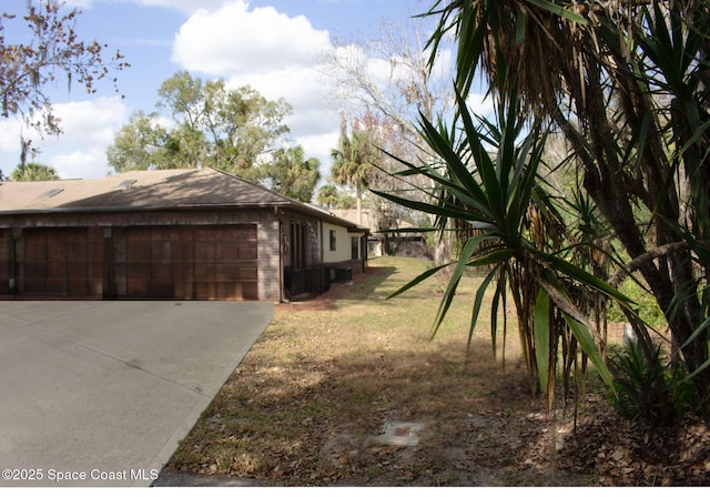 view of property exterior featuring a garage and a lawn