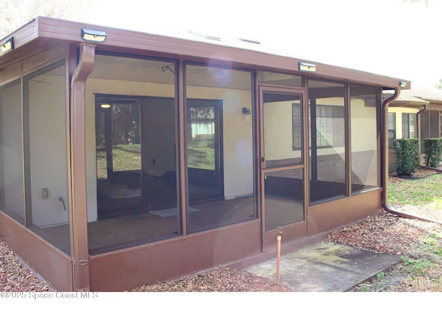 rear view of property featuring a sunroom