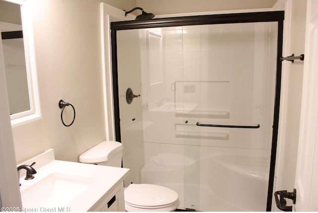 bathroom featuring vanity, toilet, and a shower with shower door