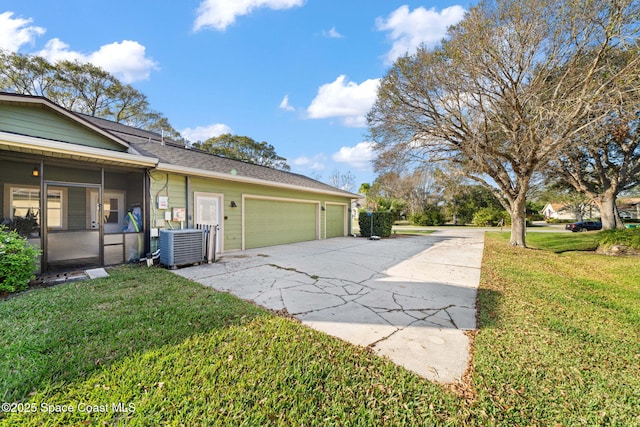 view of home's exterior with cooling unit, a garage, a yard, and a sunroom