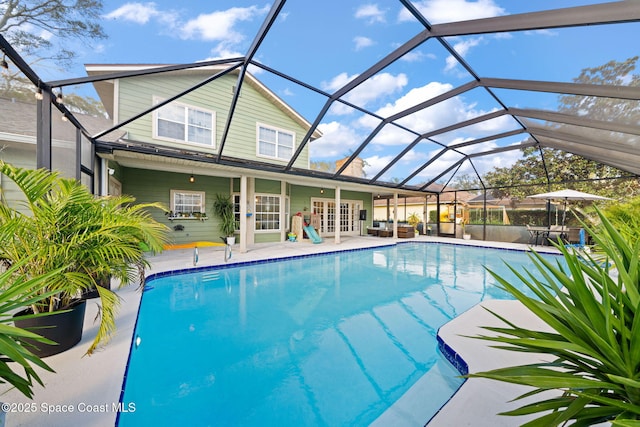 view of swimming pool featuring french doors, a lanai, and a patio