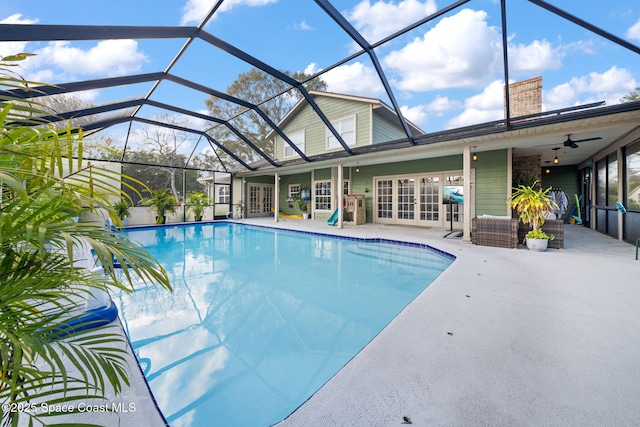 view of pool featuring a lanai, a patio area, french doors, and ceiling fan