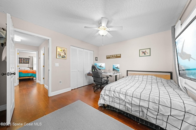 bedroom featuring ceiling fan, dark wood-type flooring, a closet, and a textured ceiling