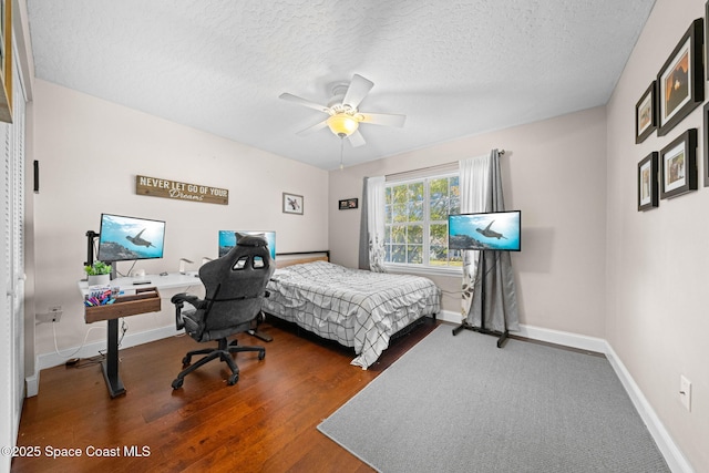 bedroom featuring ceiling fan, hardwood / wood-style flooring, and a textured ceiling