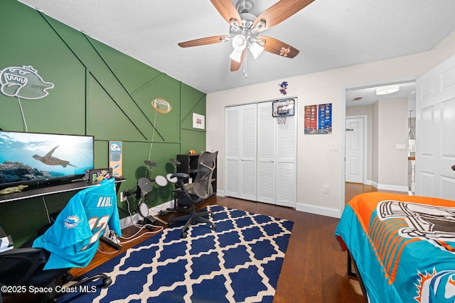 bedroom with a closet, dark hardwood / wood-style floors, and ceiling fan