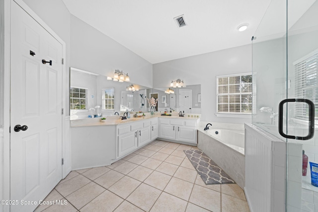 bathroom with tile patterned flooring, vanity, lofted ceiling, and a healthy amount of sunlight