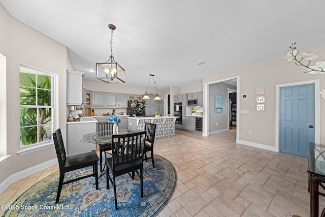 dining area with an inviting chandelier and a textured ceiling