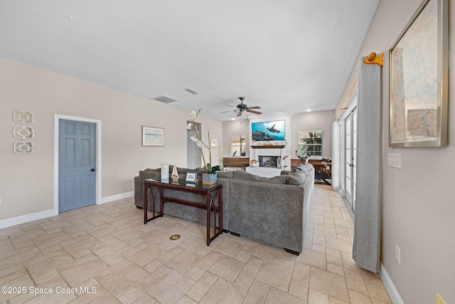 living room with a textured ceiling and ceiling fan