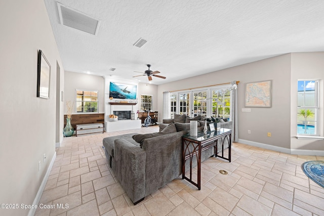 living room with ceiling fan and a textured ceiling