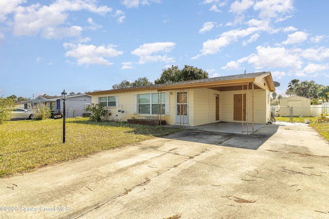 ranch-style house featuring a carport and a front lawn