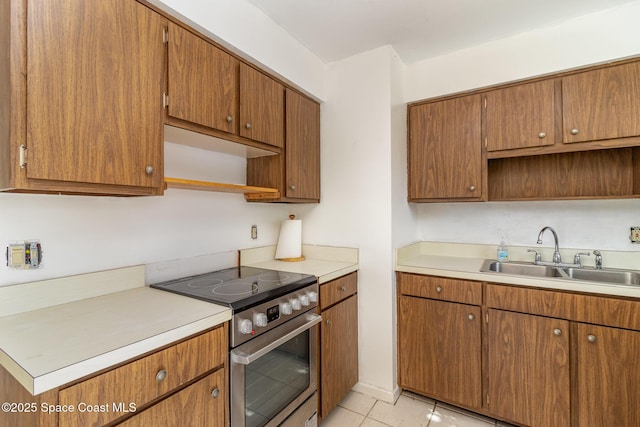 kitchen with sink, stainless steel range with electric cooktop, and light tile patterned floors