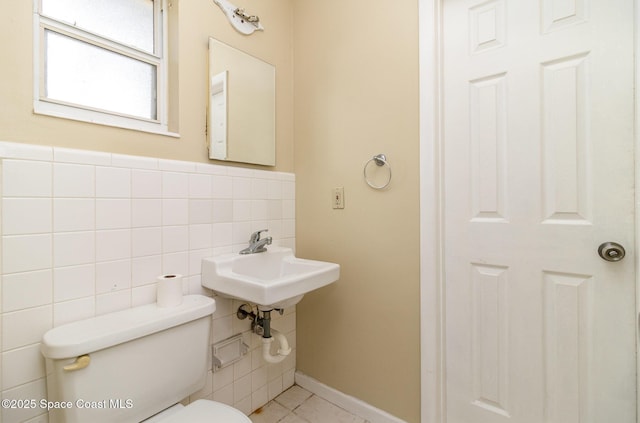 bathroom with toilet and tile walls