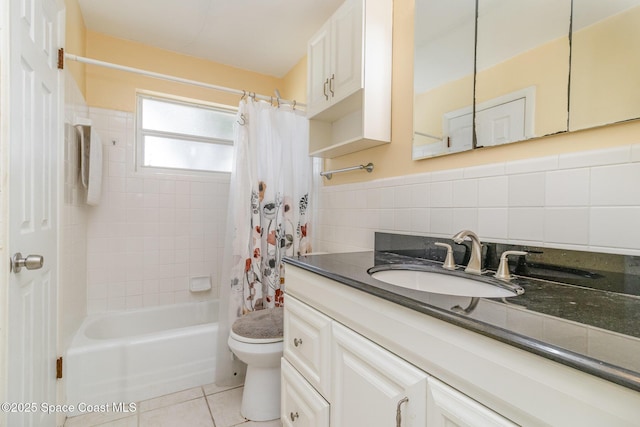 full bathroom featuring tile walls, shower / bath combination with curtain, vanity, toilet, and tile patterned floors