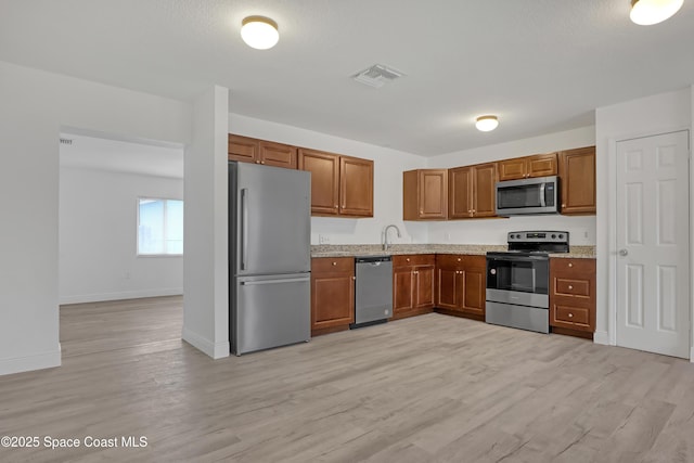 282 Hollywood Blvd, Melbourne, FL 32904 - kitchen featuring light stone countertops, appliances with stainless steel finishes, sink, and light hardwood / wood-style floors