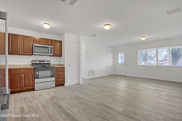 282 Hollywood Blvd, Melbourne, FL 32904 - kitchen featuring light hardwood / wood-style flooring, light stone countertops, and appliances with stainless steel finishes