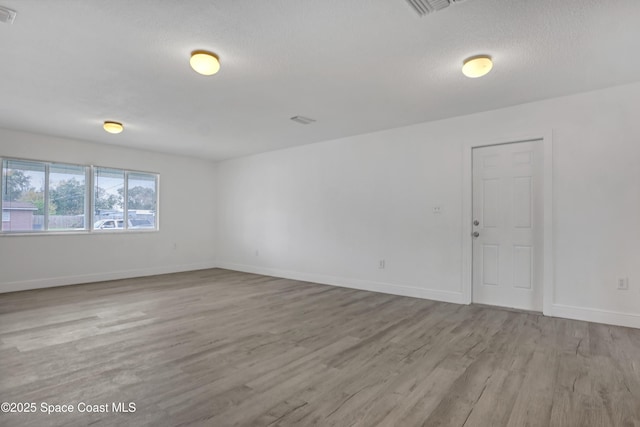 282 Hollywood Blvd, Melbourne, FL 32904 - empty room with a textured ceiling and light hardwood / wood-style floors