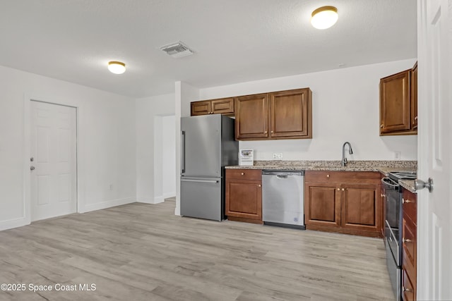 282 Hollywood Blvd, Melbourne, FL 32904 - kitchen with appliances with stainless steel finishes, sink, light stone counters, and light hardwood / wood-style flooring