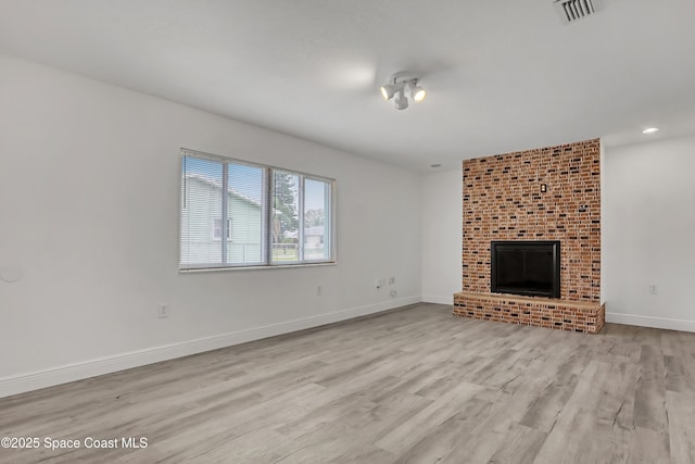 282 Hollywood Blvd, Melbourne, FL 32904 - unfurnished living room with a brick fireplace and light hardwood / wood-style flooring