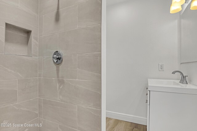 282 Hollywood Blvd, Melbourne, FL 32904 - bathroom featuring vanity, wood-type flooring, and a tile shower