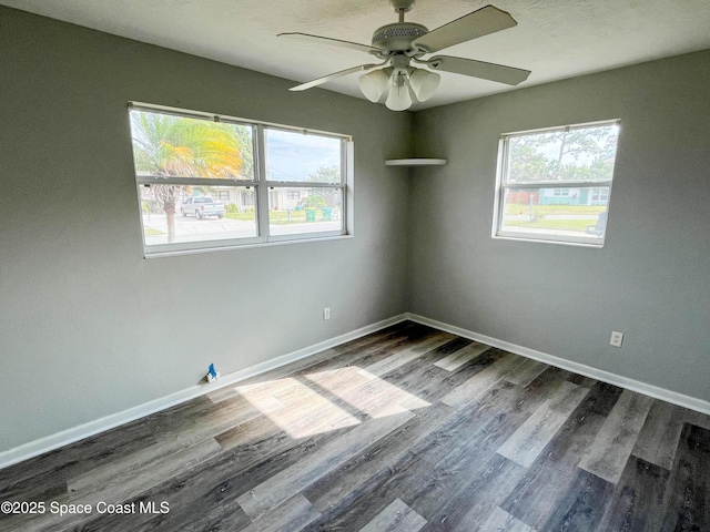 unfurnished room featuring dark wood-type flooring and ceiling fan