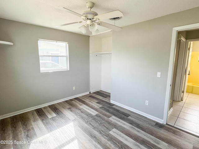 unfurnished bedroom with ceiling fan, dark hardwood / wood-style flooring, and a closet