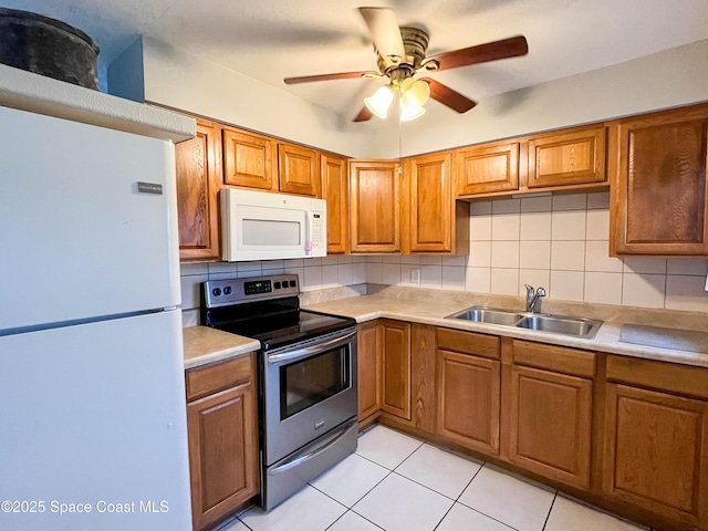 kitchen featuring tasteful backsplash, sink, light tile patterned floors, ceiling fan, and white appliances