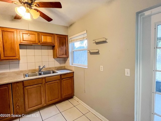 kitchen featuring tasteful backsplash, sink, light tile patterned floors, and ceiling fan