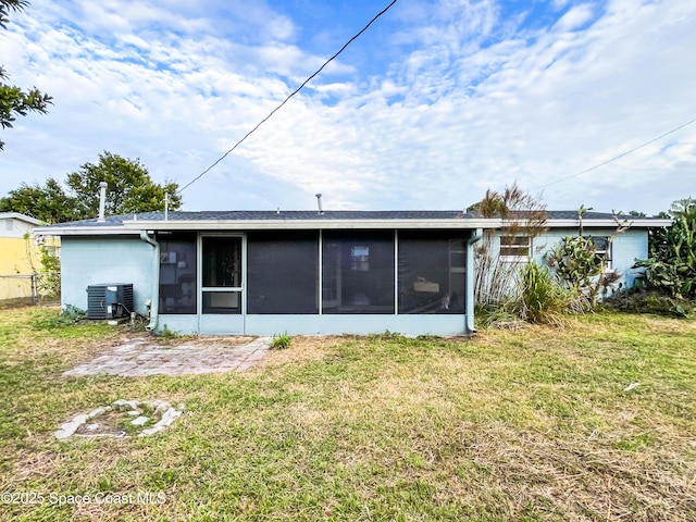 back of property featuring a yard, a sunroom, and central air condition unit