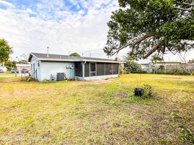 back of property with a sunroom and a lawn