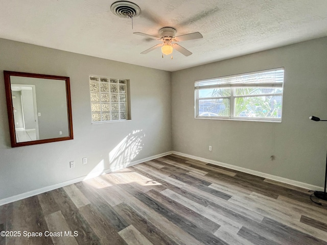 unfurnished room featuring wood-type flooring, ceiling fan, and a textured ceiling