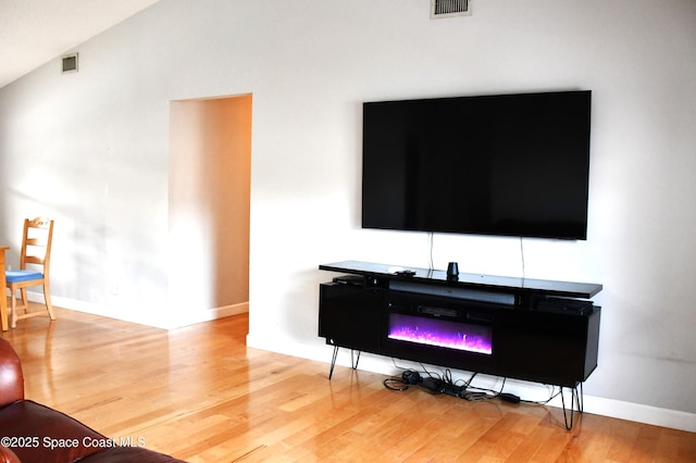 living room with hardwood / wood-style flooring and vaulted ceiling