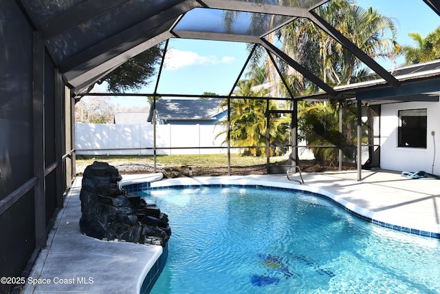 view of pool with a patio and glass enclosure