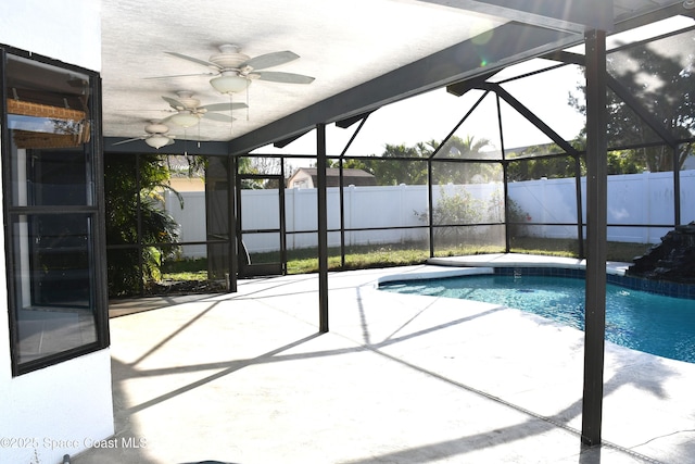 view of swimming pool with a patio area, ceiling fan, and glass enclosure