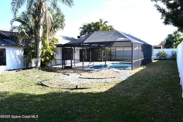 back of house featuring a fenced in pool, a yard, glass enclosure, and a patio area