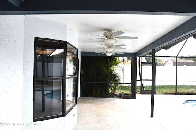 unfurnished sunroom featuring ceiling fan