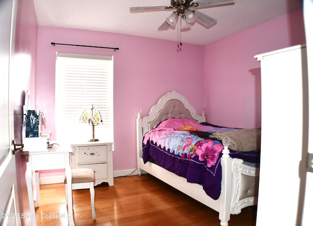 bedroom featuring hardwood / wood-style flooring, ceiling fan, and a textured ceiling