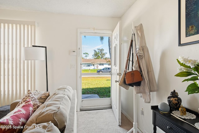 doorway with light carpet and a textured ceiling