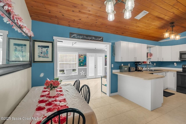 kitchen with hanging light fixtures, sink, white cabinets, and black electric range oven