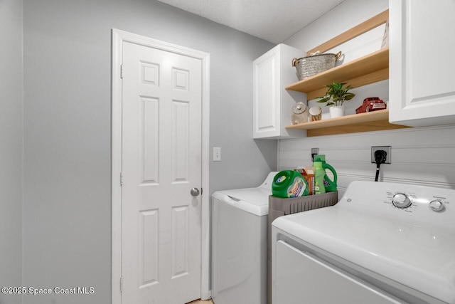 laundry area with cabinets and washing machine and clothes dryer