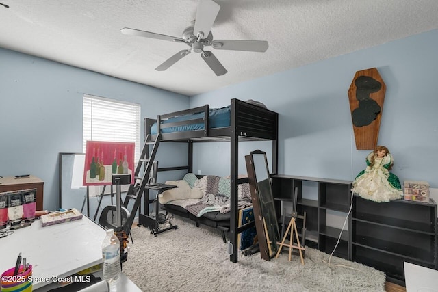 bedroom with ceiling fan and a textured ceiling