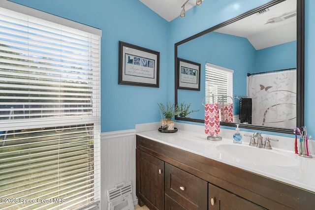 bathroom with a shower with curtain, lofted ceiling, and vanity