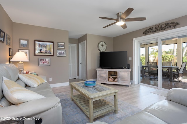 living room featuring light hardwood / wood-style floors and ceiling fan