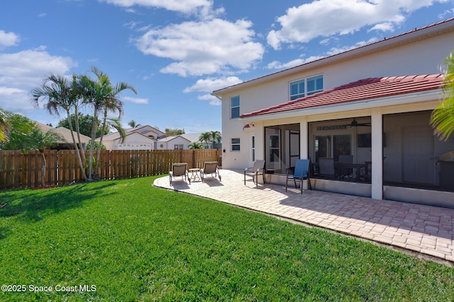 rear view of house featuring a yard, ceiling fan, and a patio area