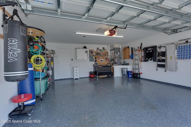 garage with a garage door opener, a workshop area, and electric panel