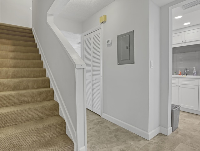 stairs with electric panel and sink