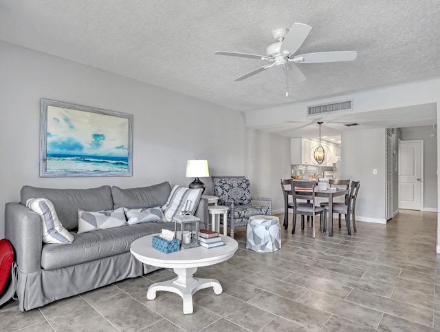 living room featuring a textured ceiling and ceiling fan