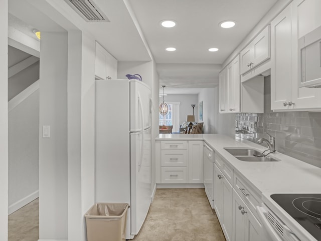 kitchen featuring sink, white appliances, tasteful backsplash, white cabinets, and kitchen peninsula