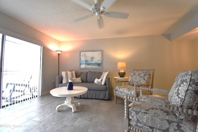 living room featuring ceiling fan and a textured ceiling