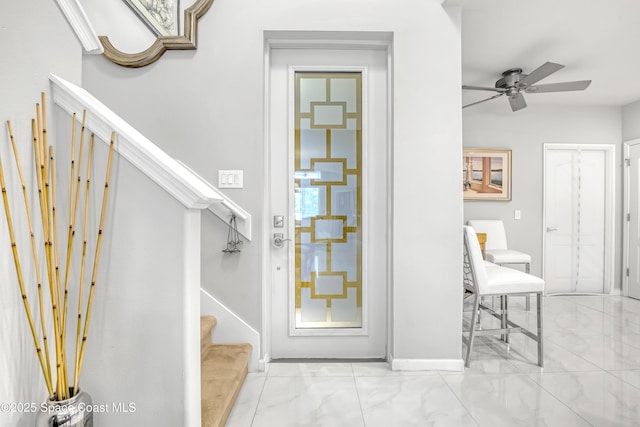 interior space featuring baseboards, marble finish floor, and a ceiling fan